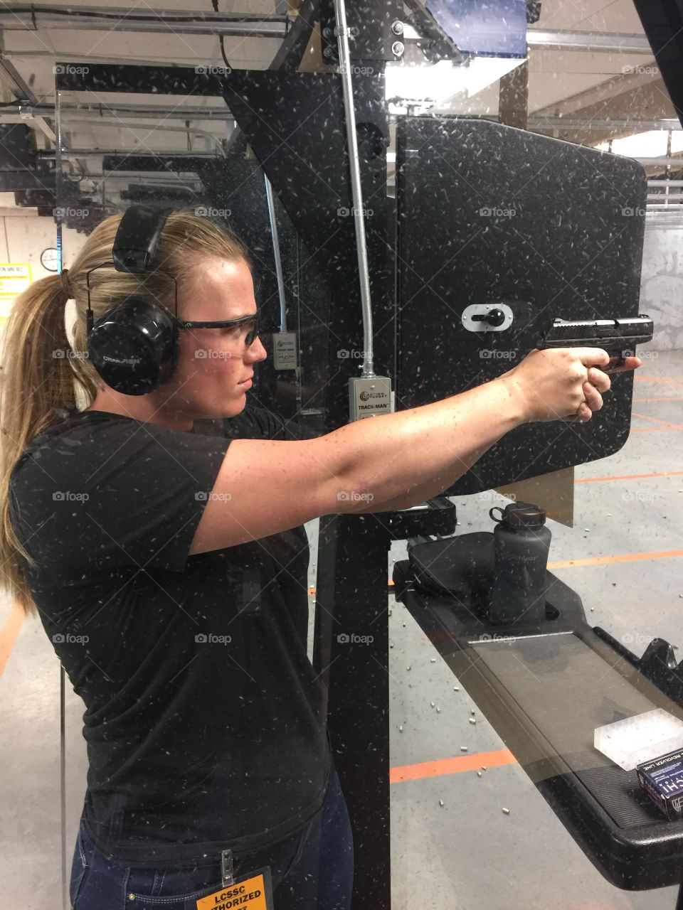 Woman shooting gun at shooting range