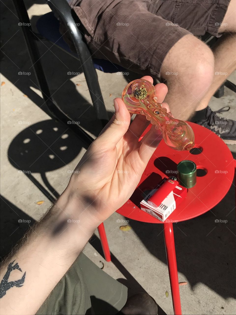 smoking. freshly packed bowl of weed in a brand new iridescent glass pipe. 