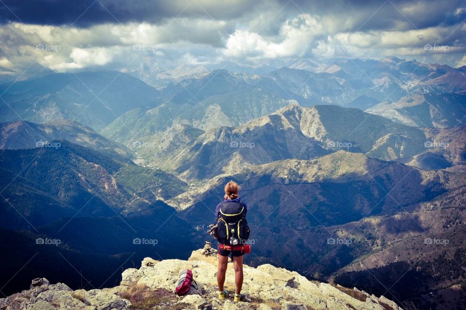 hiker standing on a mountain peak, view to the italian alps.