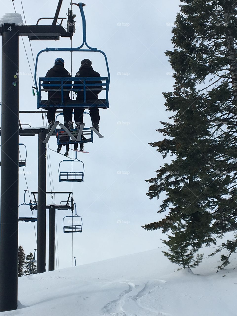 Two skiers on a ski lift