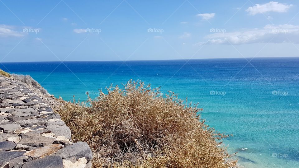 View of beautiful turquoise sea on a sunny day in Fuerteventura, Canary Islands Spain - utsikt över vackert turkost blått hav i sol , Kanarieöarna Spanien