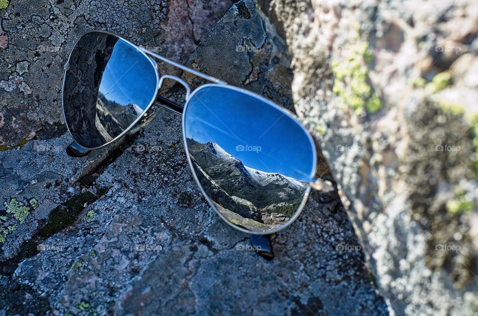 Snow capped mountain reflected on sunglasses 