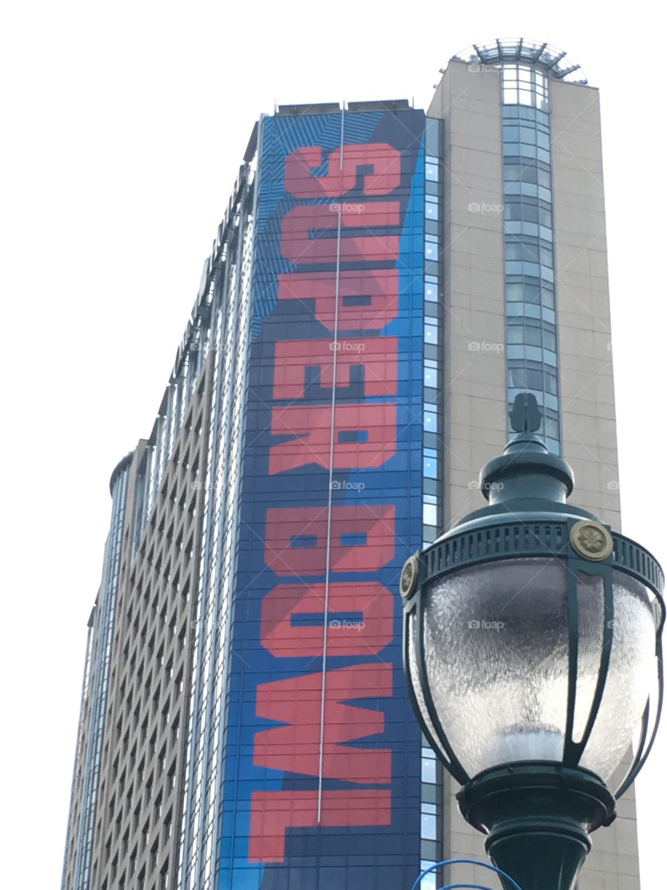 Cool lightpost with building behind covered in Super Bowl signage